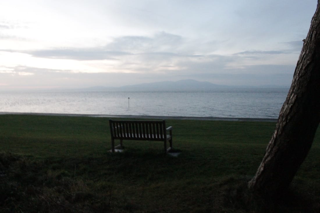 A bench in the Silloth Green, Criffel Scotland in the background