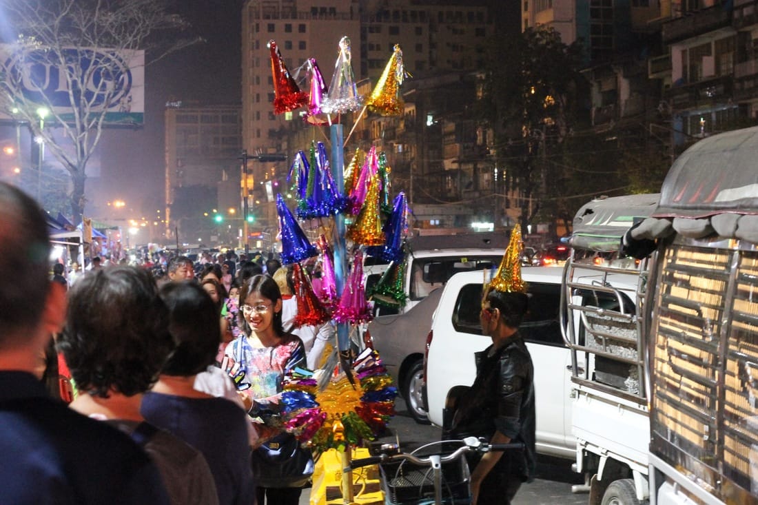 Crowded market and vendor with birthday hats